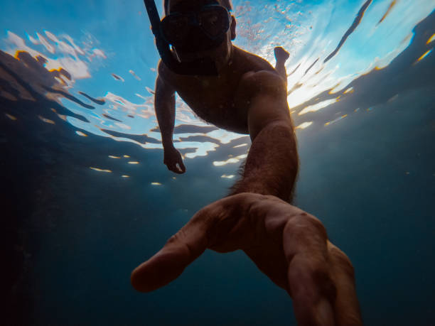 istock Man snorkeling underwater and reaching hand 1178805673