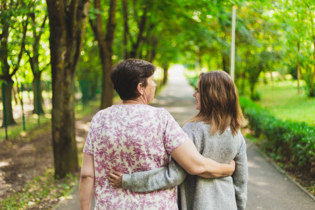 Mother and daughter walking in the park stock photo