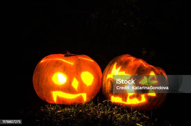 Illuminated Scary Halloween Pumpkins Shining In Dark Night Stock Photo - Download Image Now