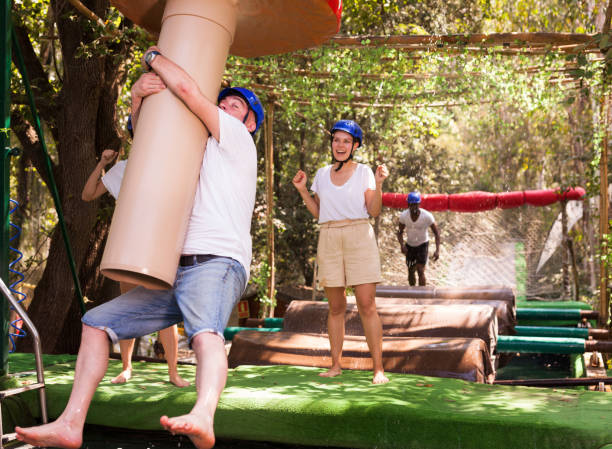 istock Friends help each other overcome water obstacles in theme park 1178807802