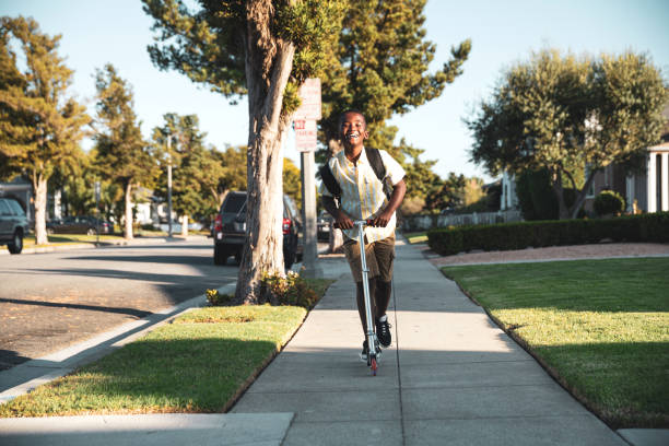 istock Afro american kid coming back from school with scooter 1178808749