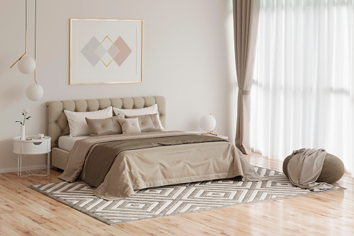 Acogedor dormitorio en colores cálidos con pintura, una mesita de noche, un puf, y un a cuadros photo