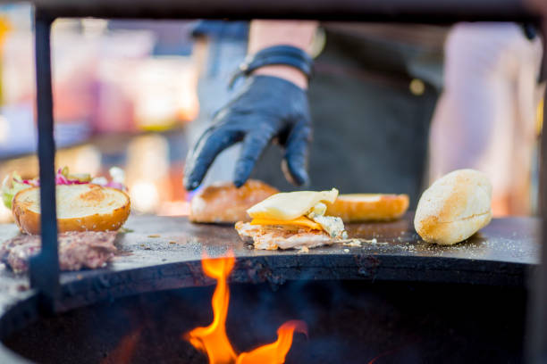 istock gloved hand collects a patty, cheese and vegetables on a burger roll. Ready order 1178811501