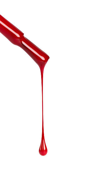 Nail brush with red polish dripping on a white background