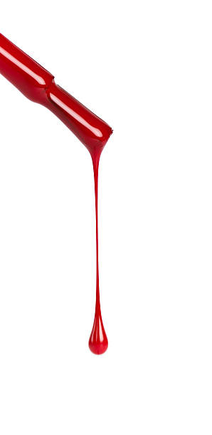Nail brush with red polish dripping on a white background stock photo