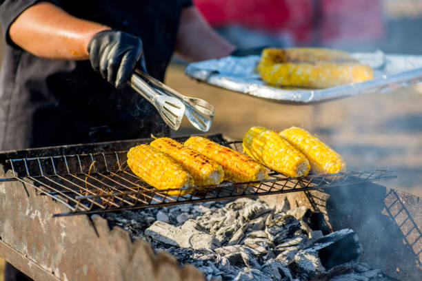 istock cook in gloves fry corn on an open barbecue fire 1178811691