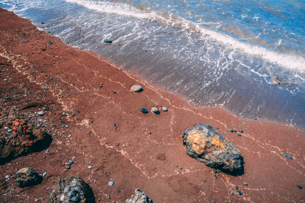 07/13/2018 - Santorini, Greece - Waves crashing against rocks on Red Beach