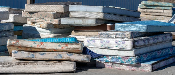 Mattress Recycling Center Dirty used mattresses piled at recycling site. mattress stock pictures, royalty-free photos & images
