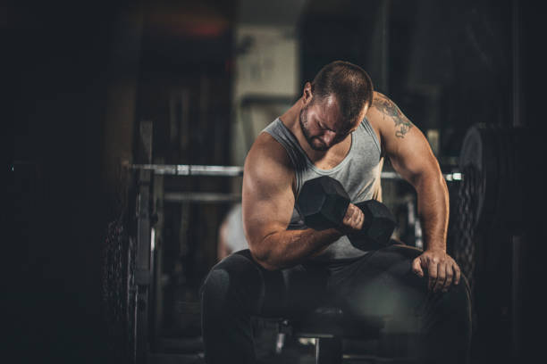 istock Muscular man doing exercises with dumbbells 1178818266