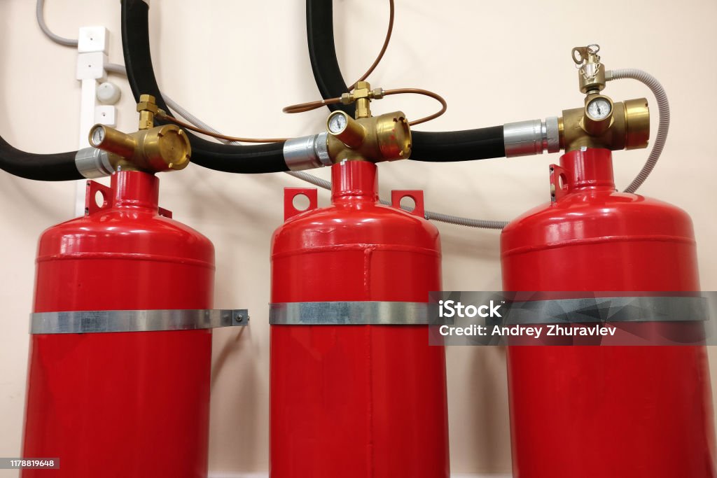 Automatic gas fire extinguishing system. Safety of premises from conflagration. Red compressed gas cylinders to prevent fire. Domination Stock Photo
