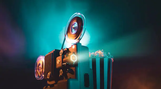 Vintage old fashioned projector in a dark room projecting a film, cinematography concept