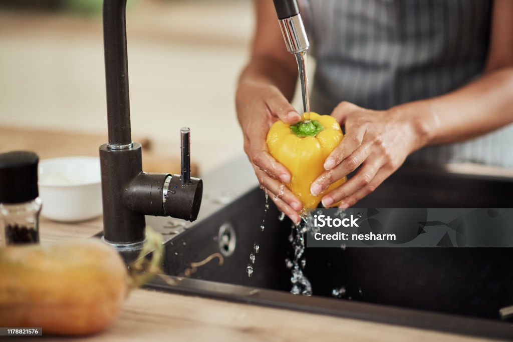 Frau waschen Pfeffer in der Küche Waschbecken. - Lizenzfrei Gemüse Stock-Foto