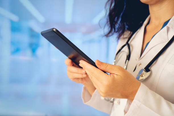 istock Woman doctor using tablet computer while standing straight in hospital 1178821745