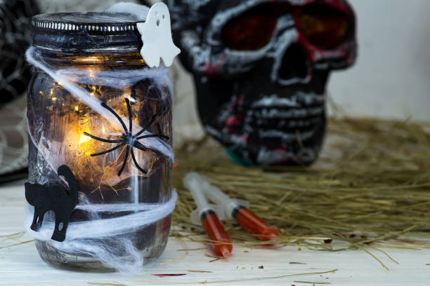 istock Jar filled with orange string lights in spooky room full in a black jar with a web and a spider on a dark background 1178822328