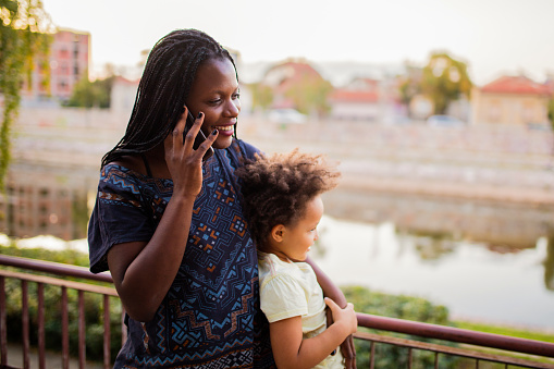 African American woman with child using phone