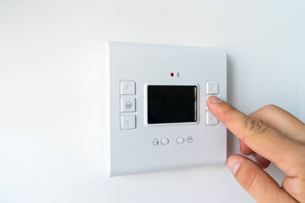 istock Man hand setting the room temperature on a modern programmable thermostat water heater (boiler). Smart home. 1178825748