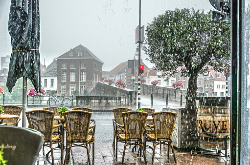 Roermond, The Netherlands, July 12, 2019: a heavy rainstorm as seen from one of the outdoor cafes near the Stone Bridge