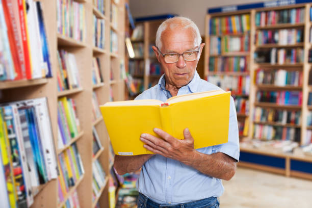 istock man absorbedly searching for interesting books 1178826065