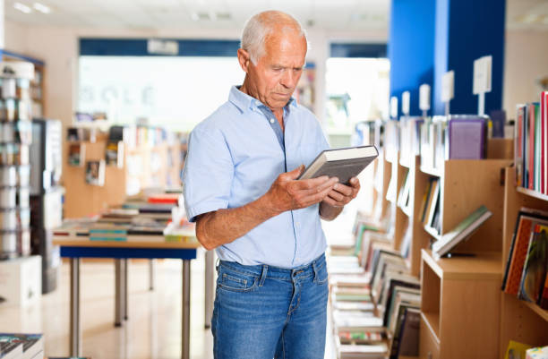 istock Focused elderly man looking for information in books in bookstore 1178826106