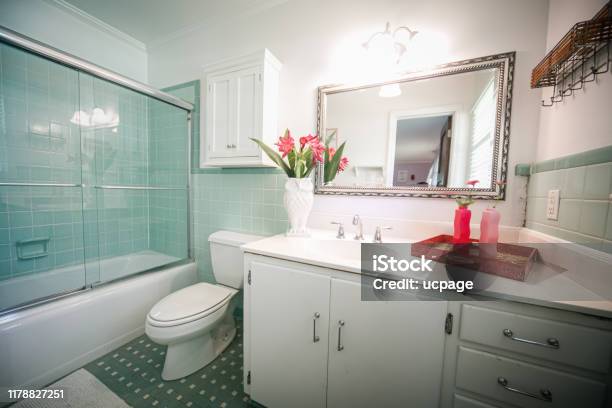 Small Outdated Tile Bathroom With A Clear Glass Door And A White Cabinet Sink Vanity And Mirror Stock Photo - Download Image Now
