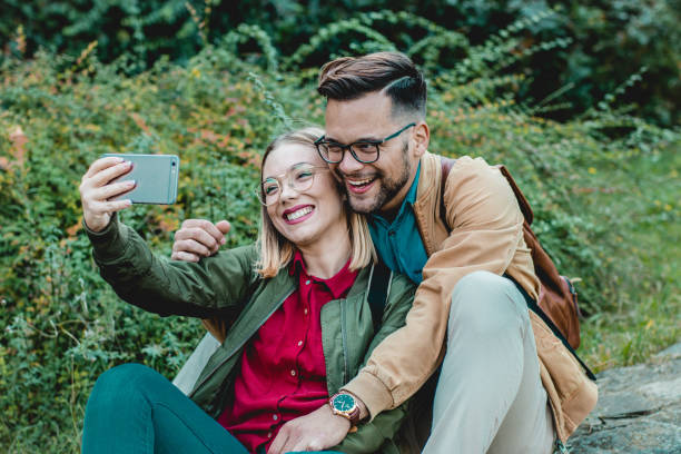 istock Young couple taking selfie in public park 1178831289