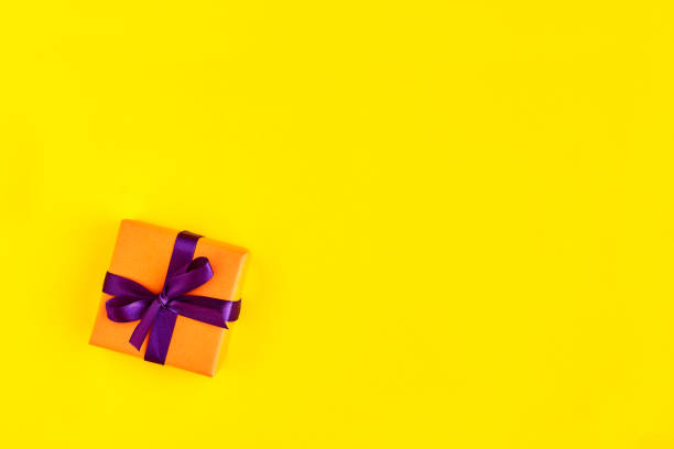istock Gift box with ribbon and bow on yellow background and space for text. Top view 1178832306