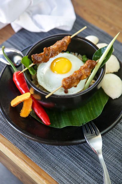 istock Nasi goreng - fried rice with chicken satay and a fried egg. Exquisite dish. Creative restaurant meal concept. 1178841722