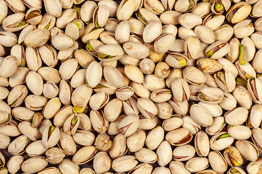 Background of laid flat pistachio nuts shot from above
