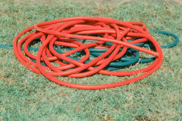 istock Red long hose on green grass 1178851308