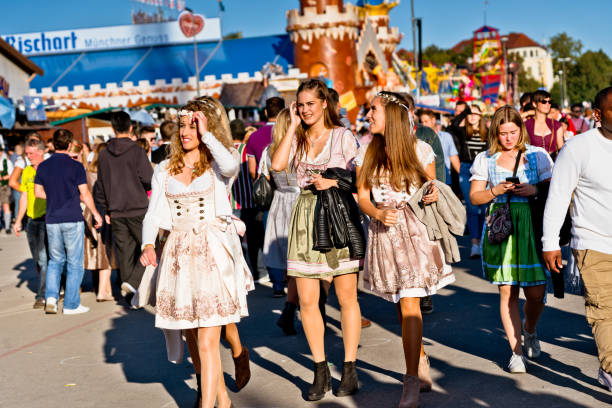 Munich, Germany - October 2nd, 2015: A man with a traditional hat in front of the Ferris wheel at the Munich Oktoberfest. An Upper Bavarian traditional hat is often decorated with a chamois beard or, as here, with an eagle down feather.
