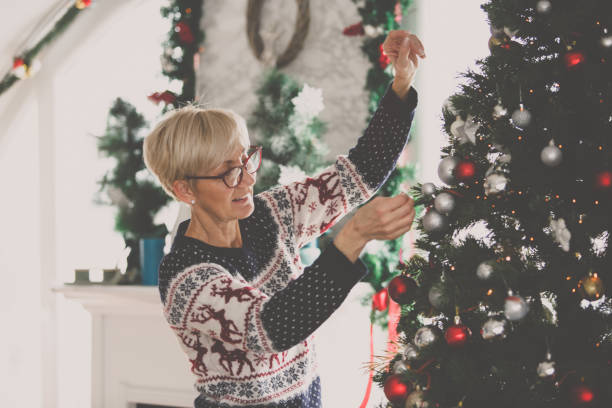 istock Senior woman decorating a large Christmas tree at home 1178859934