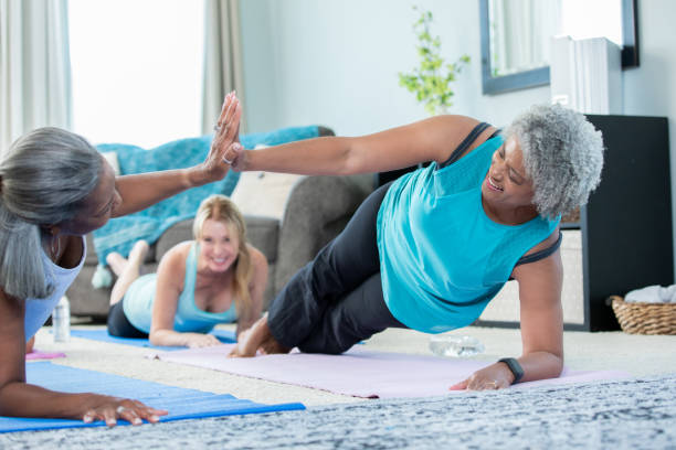 istock Senior women high five while doing planks and push ups together during at-home workout 1178860081