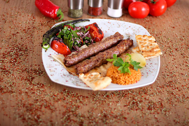 istock Roasted turkey kebabs with fresh vegetables on a wooden table filled with Turkish spices 1178862003