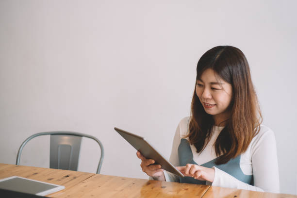 istock an asian chinese female using digital tablet surfing net at cafe 1178865053