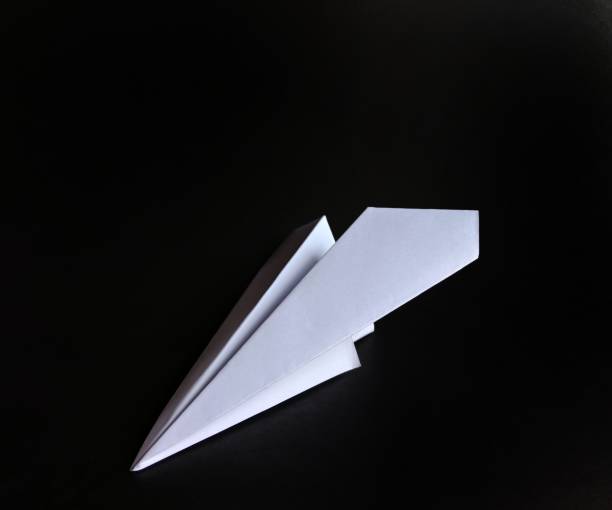 istock White paper plane on black background. funny concept 1178866746