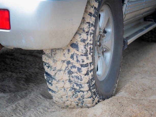 istock car wheel in the sand. 1178867525
