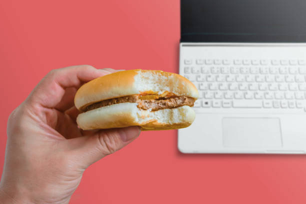 istock Person eating hamburger at desk or table. 1178869954
