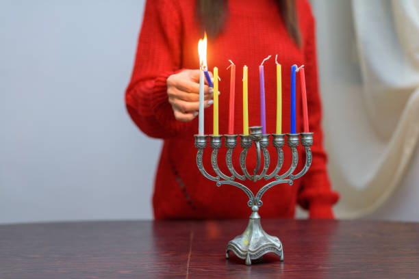 ユダヤ人女性がメノラでハヌカキャンドルを点灯。 - menorah hanukkah candle human hand ストックフォトと画像