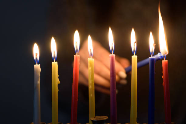 ebreo che accende candele hanukkah in una menorah. - hanukkah menorah human hand lighting equipment foto e immagini stock