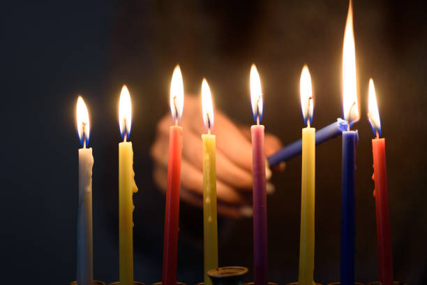 una persona che accende candele hanukkah in una menorah. - hanukkah menorah human hand lighting equipment foto e immagini stock