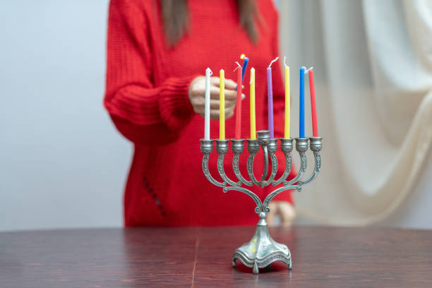 ユダヤ人女性がメノラでハヌカキャンドルを点灯。 - menorah hanukkah candle human hand ストックフォトと画像
