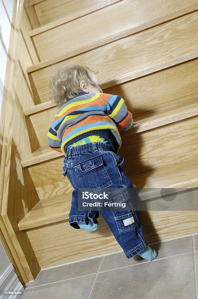 Petit garçon essaie de gravir les escaliers - Photo de Apprentissage libre de droits