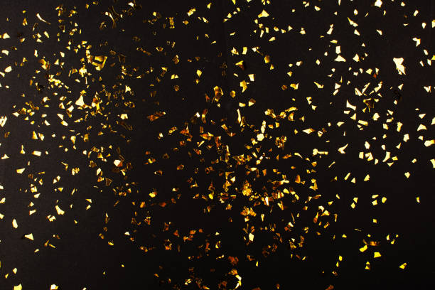 istock Gold foil confetti on black background. Flatlay. 1178881174