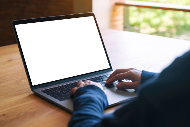 istock a woman using and typing on laptop computer keyboard with blank white desktop screen on wooden table 1178882424