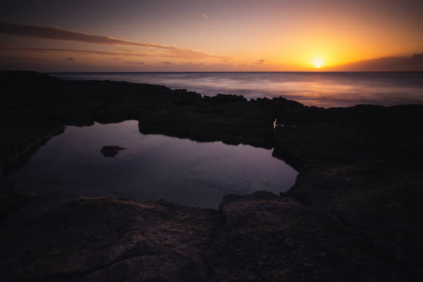istock Sunset over the ocean with rocky shore 1178884330