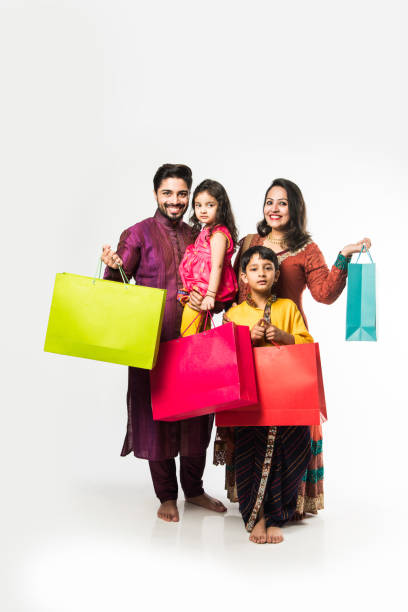 indian family of 4 celebrating diwali festival with gift boxes and diya plate while wearing ethnic cloths - kurta imagens e fotografias de stock