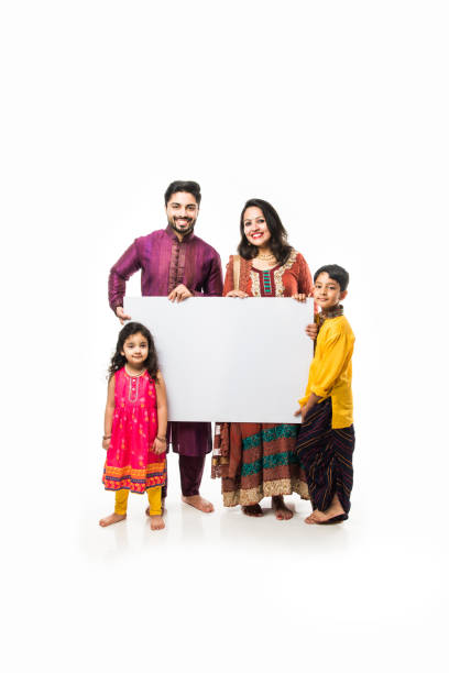 istock Indian family celebrating Diwali while holding blank white board / placard. Standing isolated over white background and looking at camera 1178888405