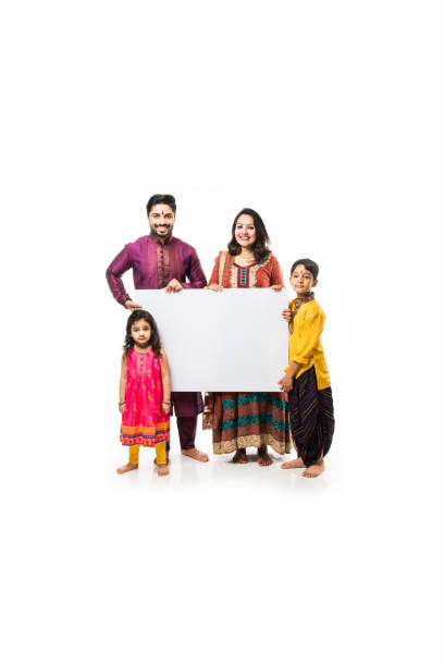 istock Indian family celebrating Diwali while holding blank white board / placard. Standing isolated over white background and looking at camera 1178888435