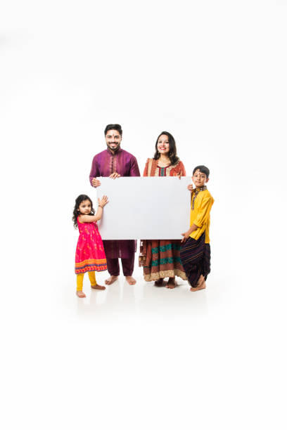 istock Indian family celebrating Diwali while holding blank white board / placard. Standing isolated over white background and looking at camera 1178889059