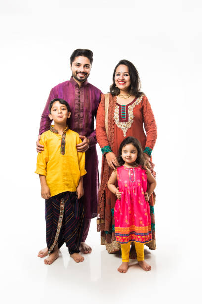 portrait of indian young family of four in traditional wear, standing isolated over white background - kurta imagens e fotografias de stock